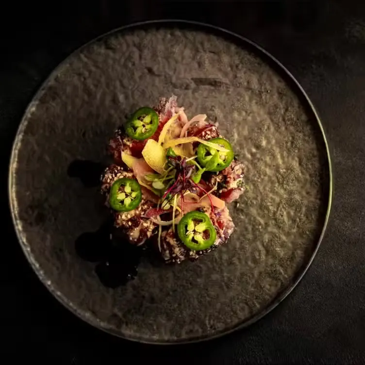 Sesame-crusted tuna tataki plated on stoneware