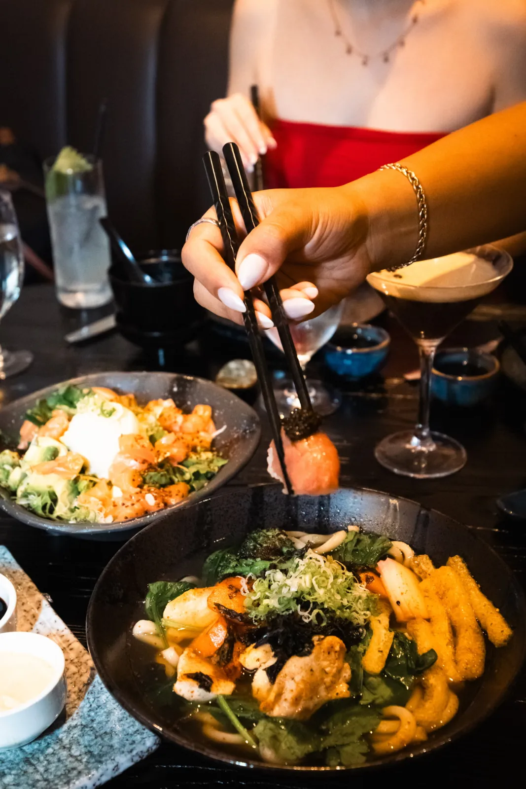 Lifting caviar nigiri over a bowl of udon