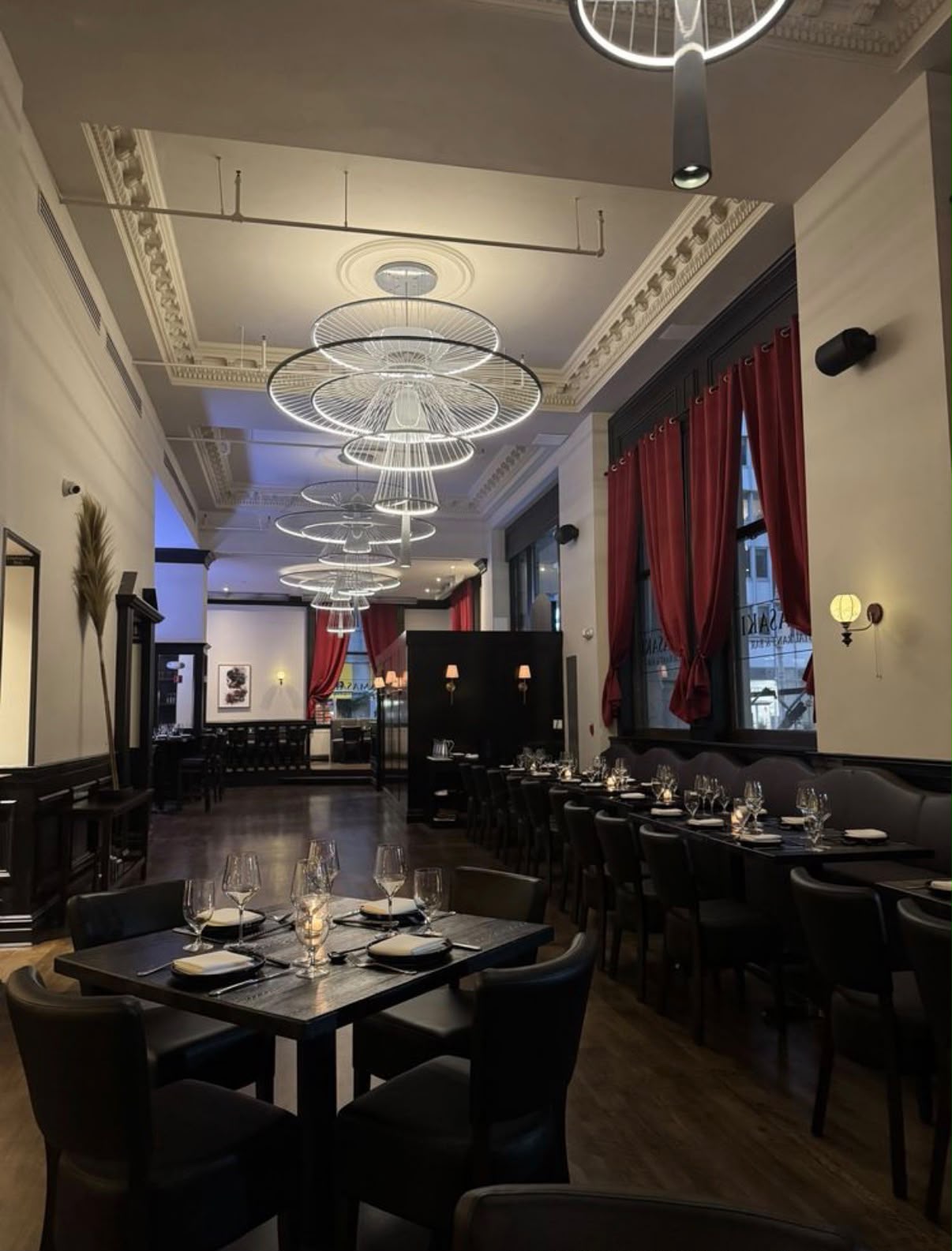The Yamasaki dining room set for evening service, with ring chandeliers and red drapery